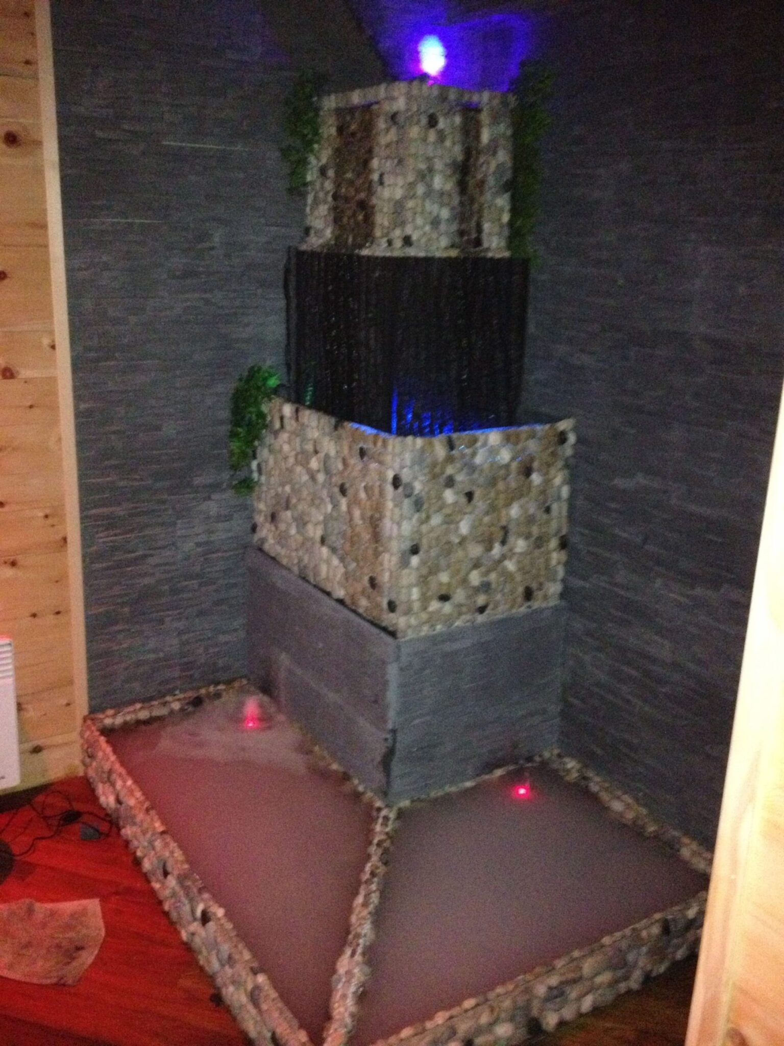 Fontaine décorative en pierre avec éclairage LED, créant une ambiance relaxante dans un espace intérieur.